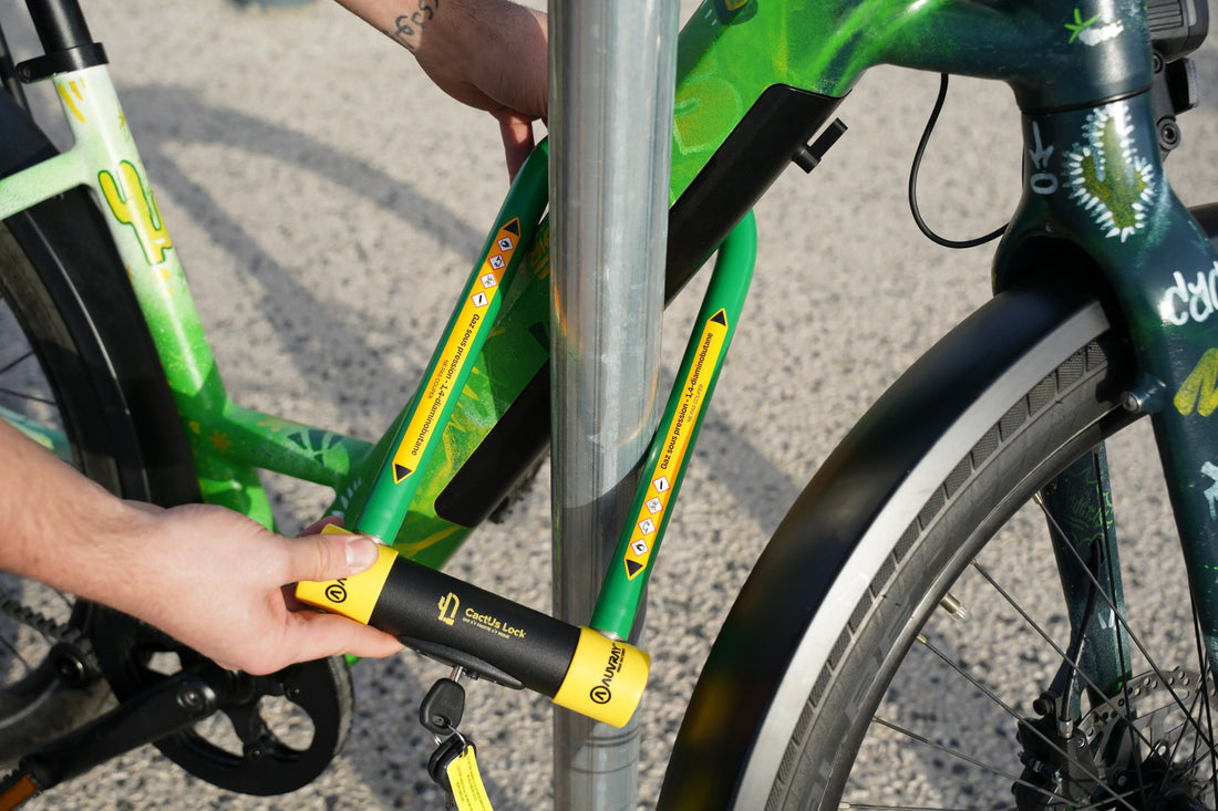 Vélo attaché avec un antivol pliable CactUs Lock autour d’un poteau en ville.
