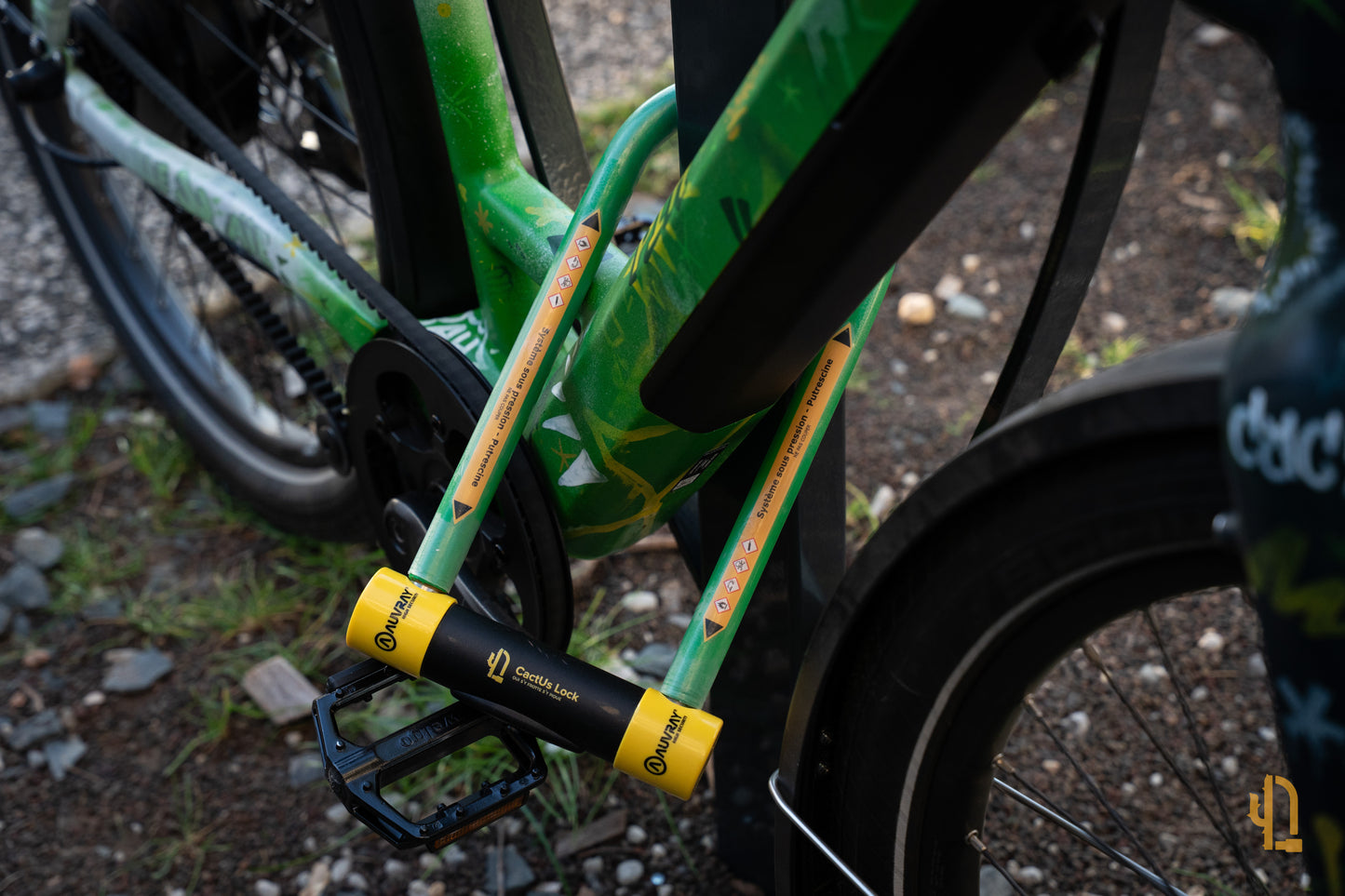 Antivol Le Pionnier de CactUs Lock verrouillé sur le cadre d’un vélo, avec signalétique de dissuasion visible contre le vol.