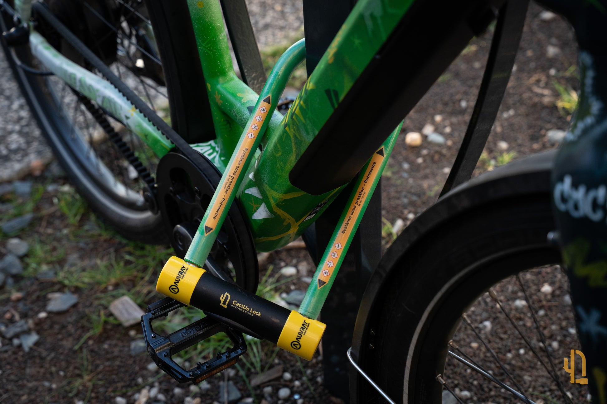 Antivol Le Pionnier de CactUs Lock verrouillé sur le cadre d’un vélo, avec signalétique de dissuasion visible contre le vol.