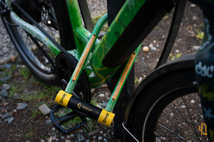 Antivol Le Pionnier de CactUs Lock verrouillé sur le cadre d’un vélo, avec signalétique de dissuasion visible contre le vol.