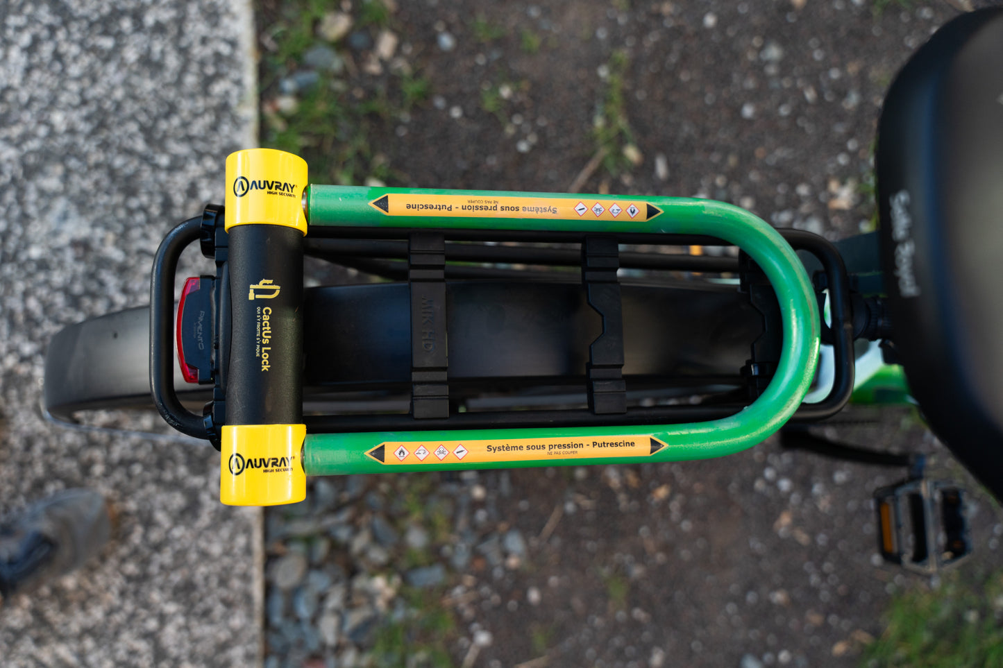 Vue de dessus de l’antivol Le Pionnier de CactUs Lock installé sur le porte-bagages d’un vélo avec signalétique de dissuasion visible.