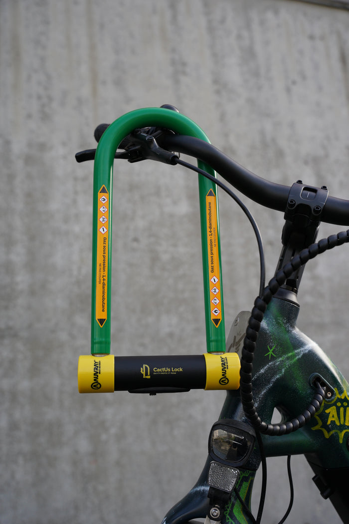 Antivol U CactUs Lock fixé au guidon d’un vélo urbain, conçu pour dissuader les tentatives de vol.